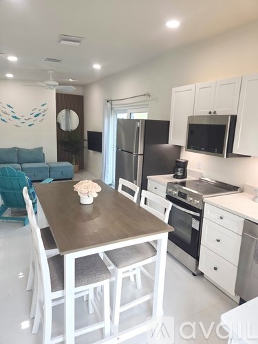 A kitchen with a table and chairs in the middle of the room.