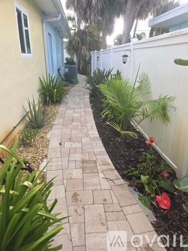 A brick pathway leads through a garden.