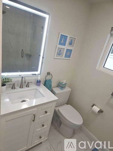 A bathroom with a toilet, sink, and a mirror.