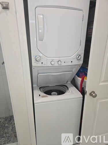 A white washing machine is sitting in a small space.