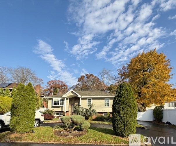 A house with a well-maintained lawn and trees in the background.