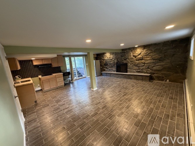 A spacious room with a stone wall and tiled flooring.