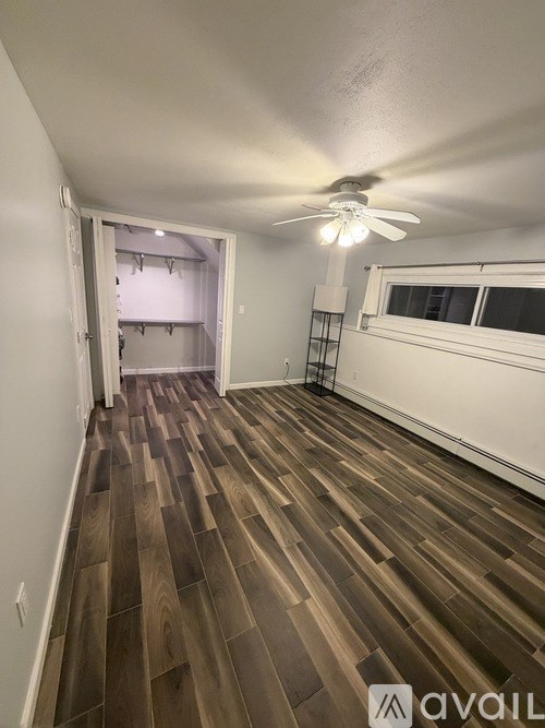 A room with wooden flooring and a ceiling fan.