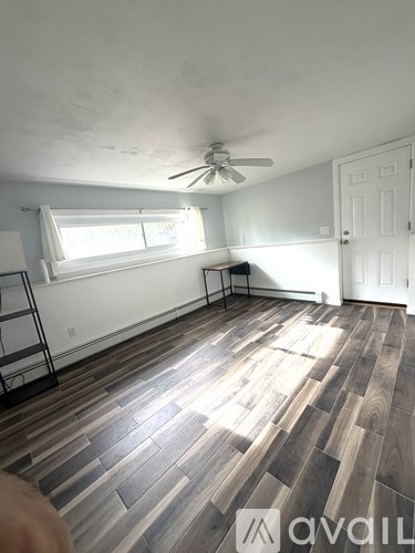 A room with wooden flooring and a ceiling fan.