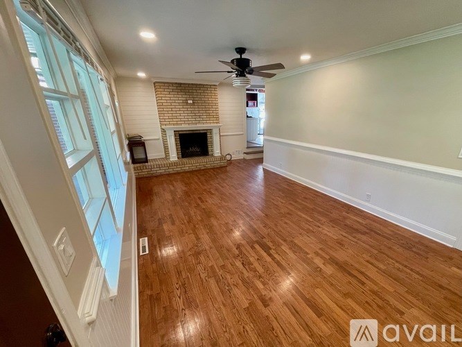 A room with a fireplace and a ceiling fan.