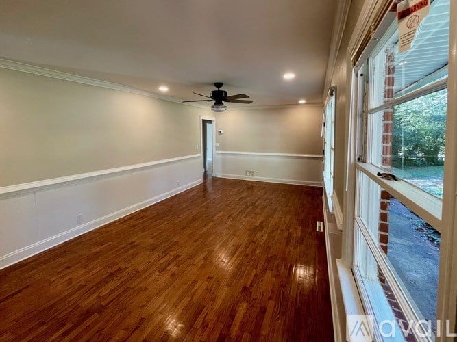 A room with wooden floors and a ceiling fan.