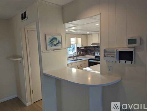 A white kitchen with a counter and a microwave.