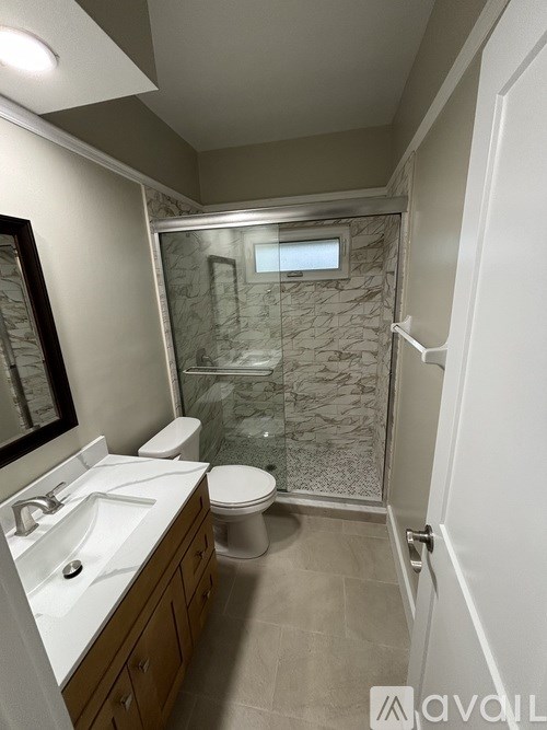 A bathroom with a toilet, sink, and shower.