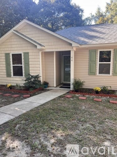A house with a grey roof and green shutters.