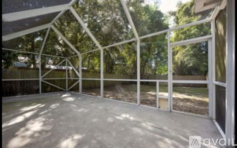 A white metal structure with a glass door is in a sunny outdoor area.