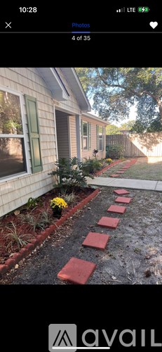 A red brick pathway leads to a house.