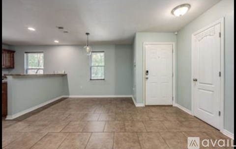 A room with a brown tile floor and white walls.
