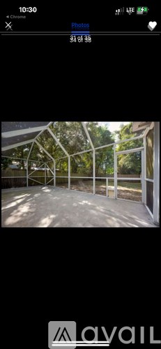 A photo of a sunny outdoor area with a white fence and trees.
