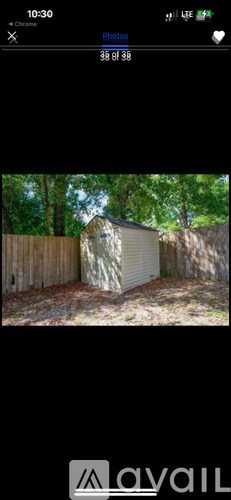 A shed is located in a backyard surrounded by a wooden fence.