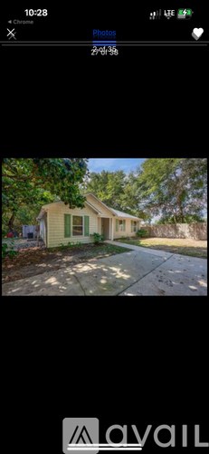 A house with a green lawn and trees in the background.