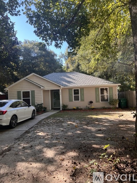 A house with a white car parked in front.