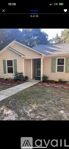 A house with a green lawn and a grey walkway.