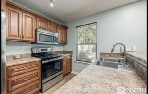 A kitchen with wooden cabinets and a granite countertop.