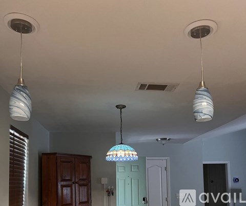 A room with a ceiling light and a hanging light fixture.