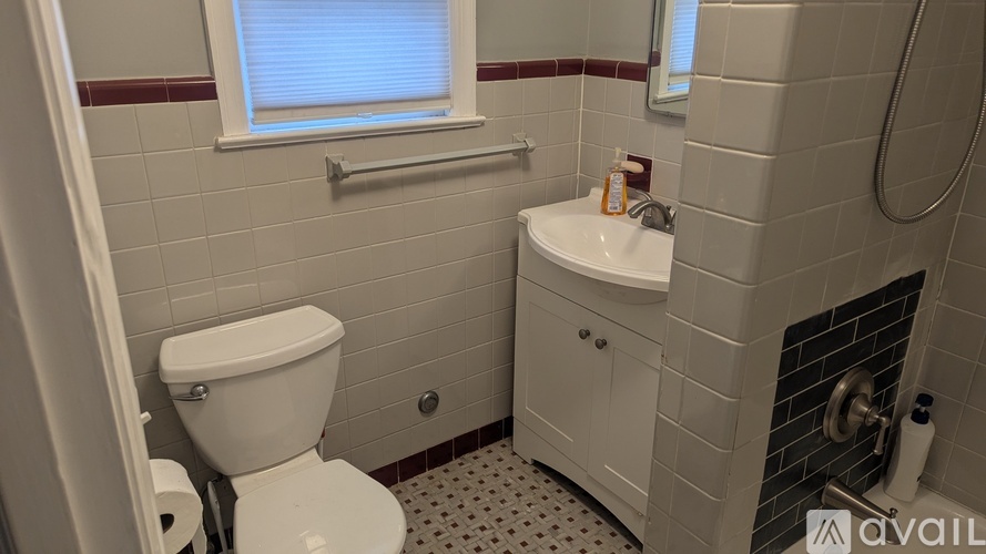 A bathroom with a toilet, sink, and window.
