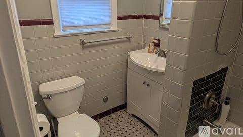 A bathroom with a toilet, sink, and window.