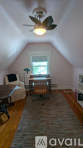 A room with a ceiling fan and a window.