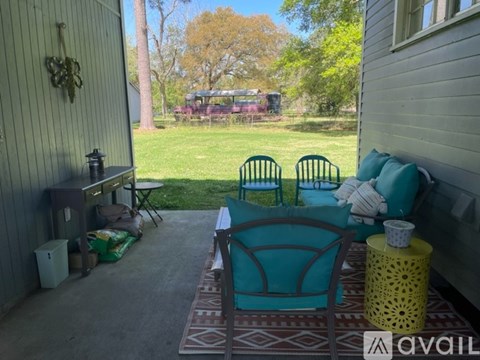 A patio with a table, chairs and a cooler.
