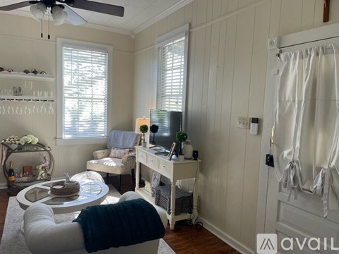 A living room with a white couch and a table with a cake on it.