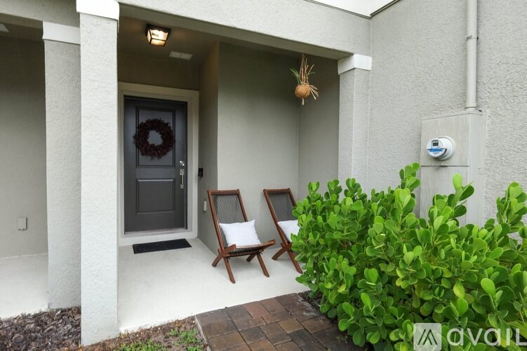 A small porch with a door and a wreath on it.