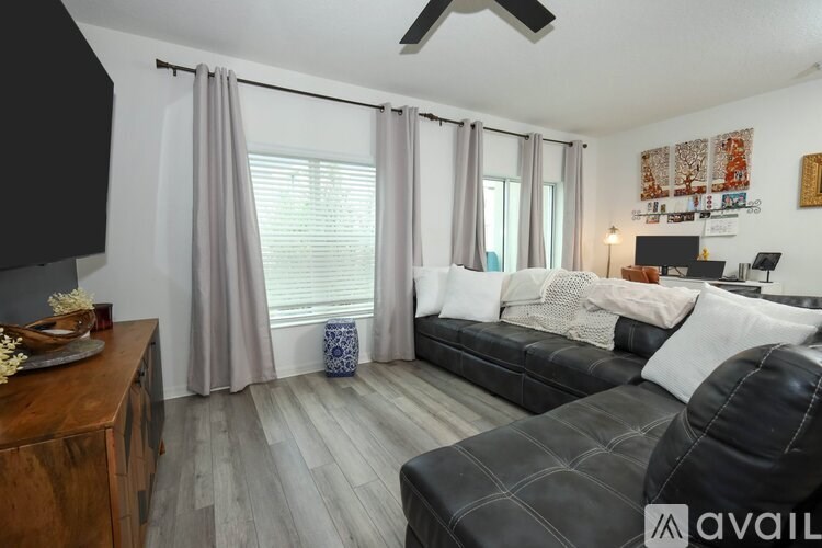 A living room with a black couch and a wooden table.