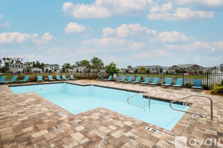 A large outdoor swimming pool surrounded by lounge chairs.