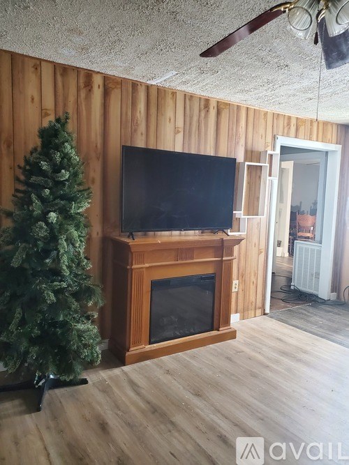 A room with a wooden wall and a television on a stand.