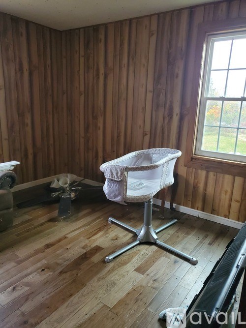 A room with wooden walls and a white chair.