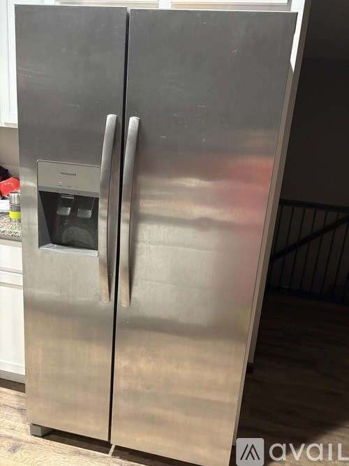 A stainless steel refrigerator with a water and ice dispenser on the door.