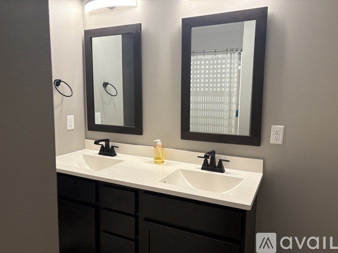 A bathroom with two sinks and two mirrors.