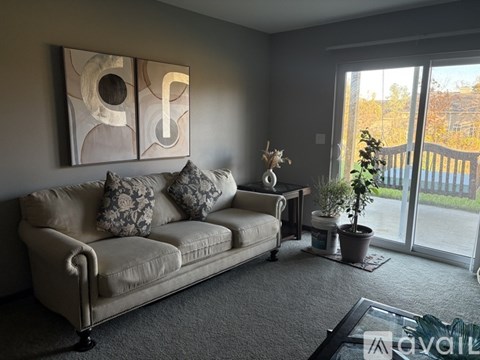 A living room with a couch, a coffee table, and a painting on the wall.