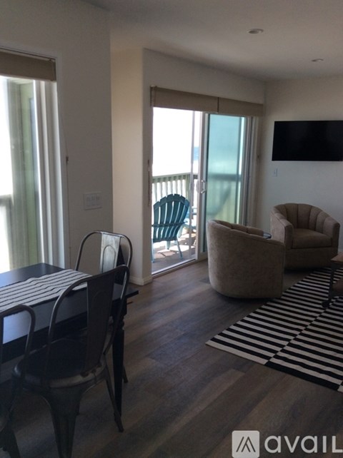 A living room with a black table and chairs.