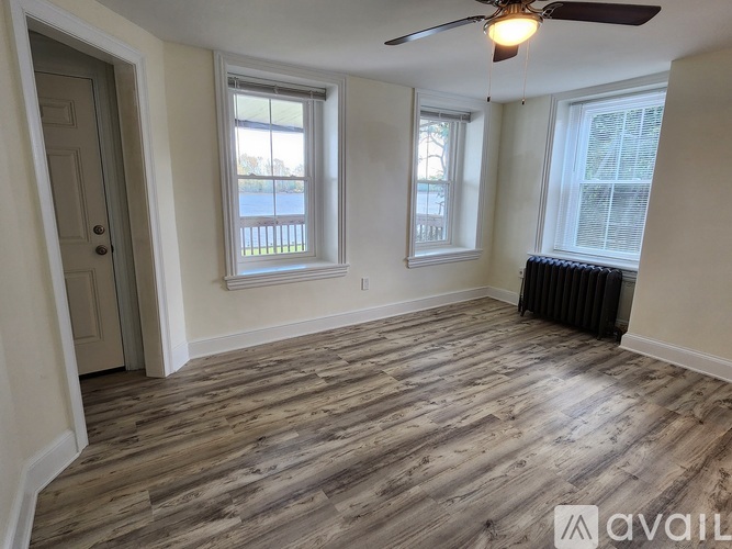 A room with wooden flooring and a ceiling fan.