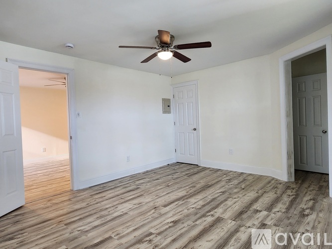 A room with a ceiling fan and wooden flooring.