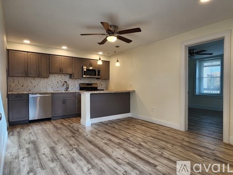 A kitchen with a white island and wooden floors.