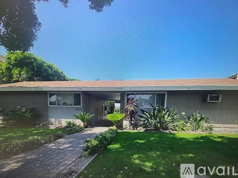 A house with a lawn and plants in front.