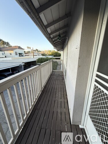 A balcony with a white railing and a wooden floor.