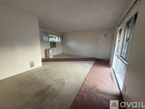 A room with a carpeted floor and a window.