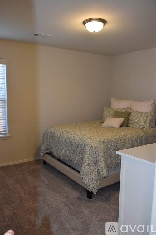 A bedroom with a bed and a nightstand.