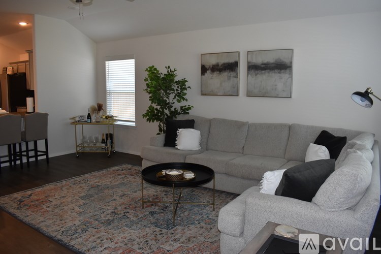 A living room with a grey couch, a coffee table, and two framed pictures on the wall.