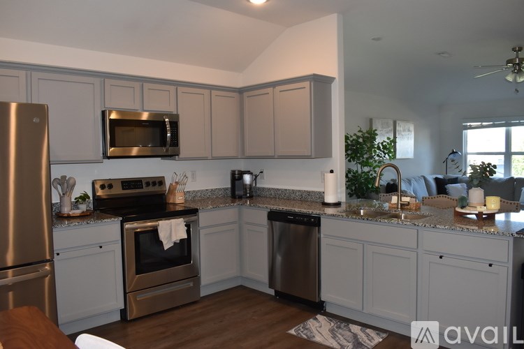 A kitchen with a refrigerator, oven, and microwave.
