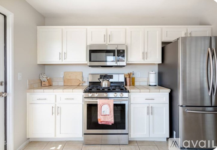 A kitchen with white cabinets and appliances.
