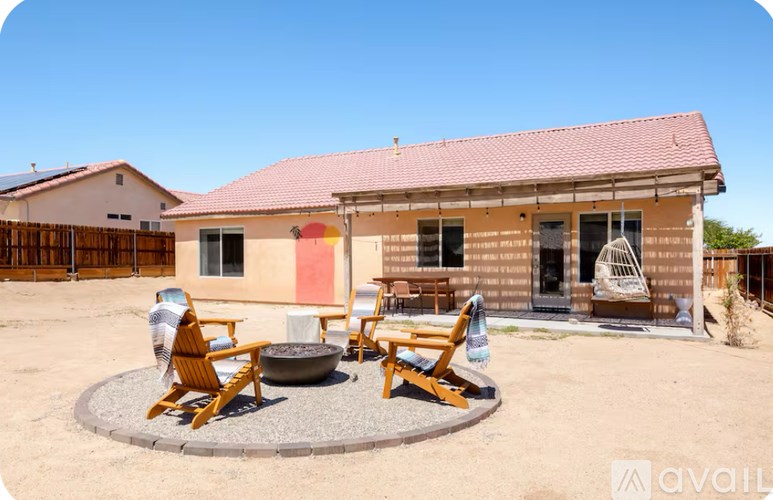 A house with a red roof and a patio with chairs and a table.