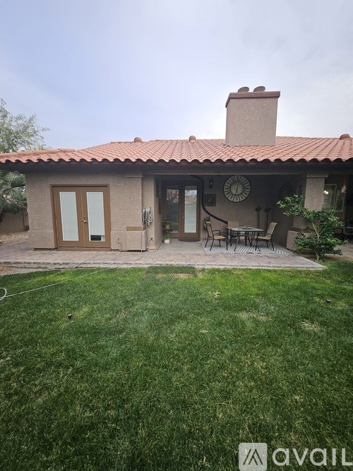 A living room with a fireplace and a television mounted above it.