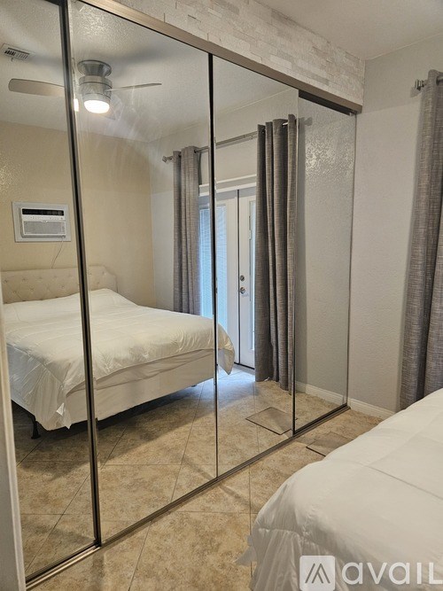 A bedroom with a large bed and a glass walled shower.